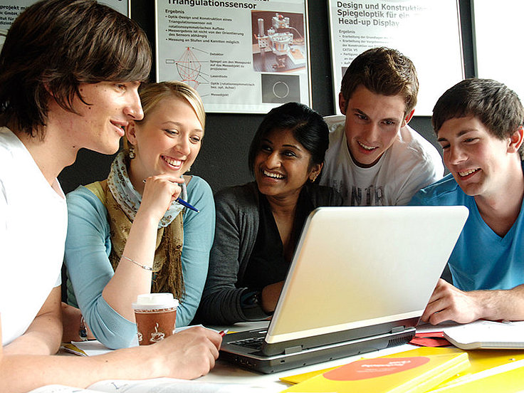 Junge Menschen sitzen vor dem Notebook